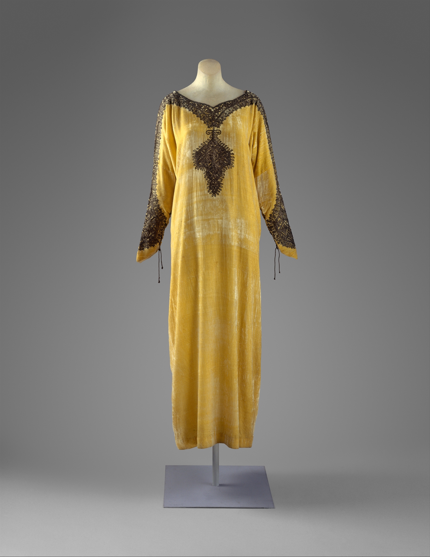 An early twentieth-century evening dress of yellow silk velvet with dark embroidery
